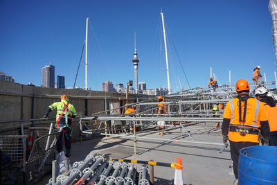 construction workers on roof overlooking auckland sky tower