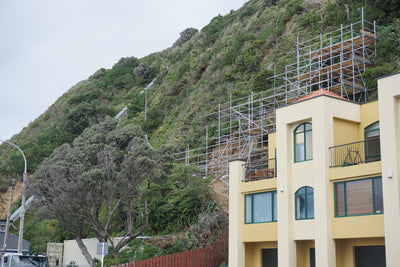 scaffolding on mountain and yellow house at front